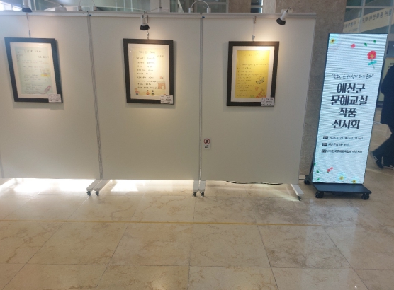 예산군은 군청 로비에서 찾아가는 문해교실 어르신들의 작품을 전시하고 있다.